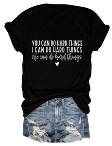 Detail of inspirational quote prints on black cotton tee with distressed denim shorts