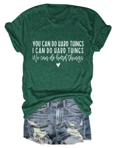 Close-up of dark green t-shirt with inspirational text paired with denim shorts