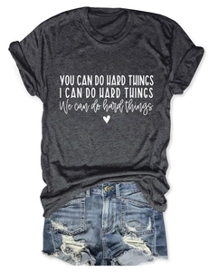 Detail of inspirational 'YOU CAN DO HARD THINGS' typography on a dark charcoal t-shirt