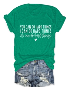 Detail of green T-shirt with 'You Can Do Hard Things' print and ripped denim shorts