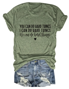 Detail of army green t-shirt with inspirational text and ripped denim shorts