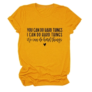 Close-up of mustard yellow cotton T-shirt featuring rolled cuffs and inspirational text print