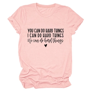 Close-up of 'you can do hard things' black text print on pink cotton t-shirt