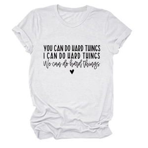 Flat lay of white crew neck t-shirt with black 'you can do hard things' quote and heart icon