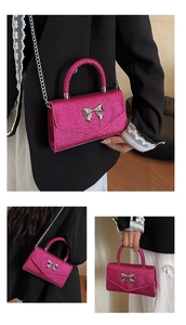 Macro shot of hot pink glitter handbag with silver bow detail and metal chain strap
