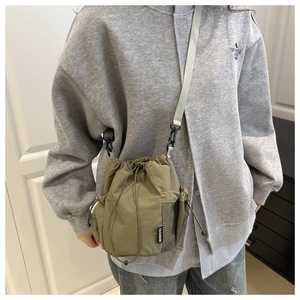 Detail der armee-grünen Nylon-Beuteltasche mit Fashion-Label und seitlichem Netzfach
