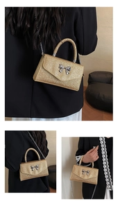 Detail of gold sequin handbag with silver bow, chain strap and woven top handle