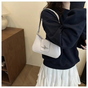 Detailansicht der weißen gewebten Schultertasche mit einer silbernen Metallschnalle
