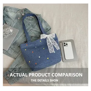 Detalle del bordado floral en bolso de mezclilla azul con lazo de encaje blanco