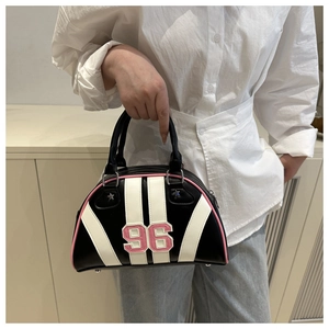 Detalle del bolso bowling con parche del número 96 y acabado elegante en cuero blanco y negro