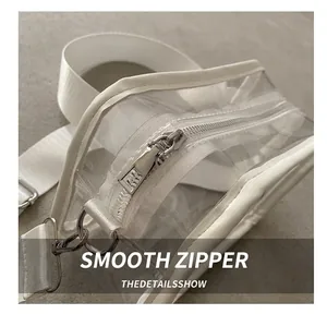 Close-up of smooth silver metal zipper on modern transparent PVC crossbody bag