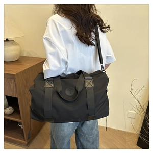 Détail du sac polochon Oxford noir avec logo Fashion 1 et poignées en cuir renforcé