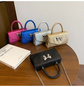 Group shot of mini glitter handbags with metal bow buckles in five vibrant colors