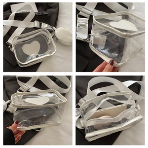 Detail view of transparent white PVC heart crossbody bag with wide strap and coin pouch