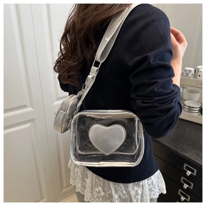 Detail of silver transparent PVC shoulder bag with heart patch and mini round pouch