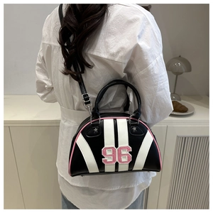 Detail van retro zwart-witte bowlingtas met roze bies en nummer 96 gedragen door model