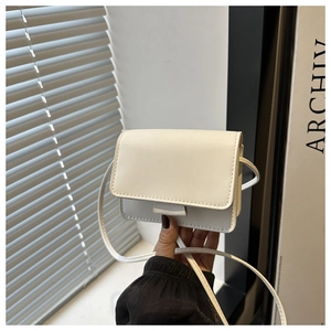 Primer plano de mini bolso cuadrado blanco en cuero sintético con solapa y correa