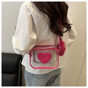 Dettaglio della borsa a tracolla trasparente a cuore con finiture rosa e borsellino