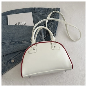Detalle de bolso bowling blanco con bordes rojos, remaches de estrella y bandolera