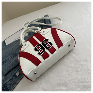 Detalle del bolso bowling rojo y blanco con bordado número 96 y remaches de estrella
