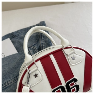 Detalle de bolso deportivo retro con rayas rojas, estrellas y parche con el número 96
