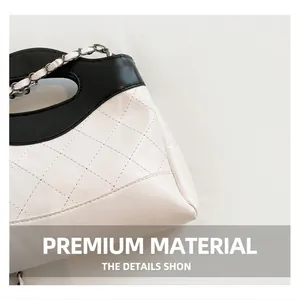 Détail des coutures sur sac en cuir matelassé blanc avec bandoulière chaîne en métal noir