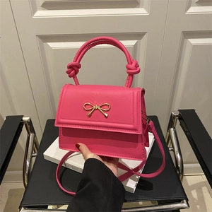 Elegante borsa rosa acceso con chiusura a fiocco dorato e manico con nodo