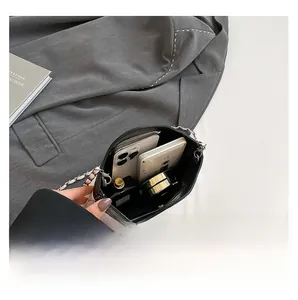 Détail de l'intérieur du sac montrant l'espace pour deux téléphones et maquillage