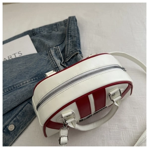 Detalle del bolso bowling blanco con rayas rojas, hebillas de estrella y asas dobles