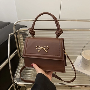 Elegante borsa a tracolla in pelle marrone scuro con fiocco dorato e manico annodato