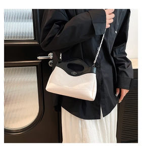 Détail du sac bandoulière matelassé noir et blanc avec anneau en métal et chaîne