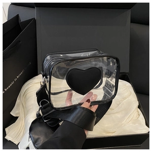 Dettaglio della borsa a tracolla in PVC trasparente con cuore nero e mini pochette