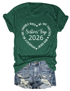 Détail de l'imprimé cœur avec texte Sisters' Trip 2026 sur un t-shirt en coton vert foncé