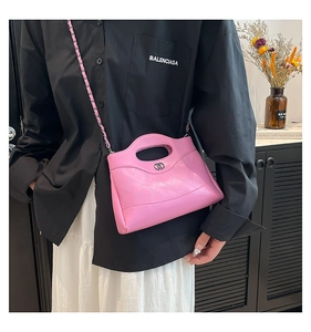 Gros plan du sac à main en cuir matelassé rose avec fermoir et chaîne
