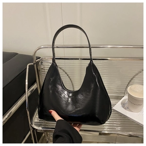 Detailed view of black glossy hobo bag with fashion embossing on a metal stand