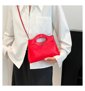 Détail du sac bandoulière matelassé rouge avec chaîne en métal et boucle ronde