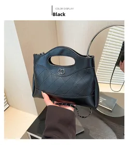 Détail du sac bandoulière matelassé noir en similicuir avec boucle métallique à anneaux argentés
