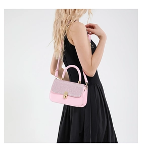 Detail of pink crossbody bag with sparkling diamond flap and golden metal handle