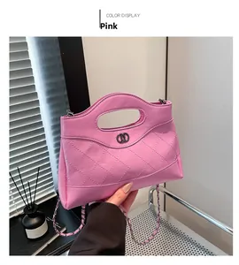 Détail du sac à main en cuir rose matelassé avec logo en métal et bandoulière