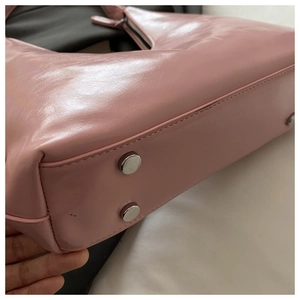 Detail shot of the pink leather bag bottom with protective silver metal base studs
