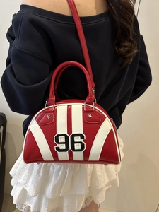 Bolso bowling retro rojo y blanco con bordado 96 y remaches de estrella llevado por modelo