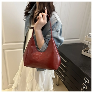 Close-up of the wine red glossy leather shoulder bag showing the FASHION lettering detail