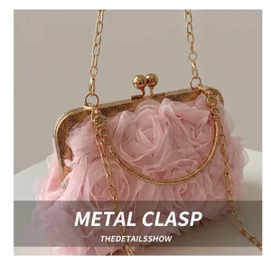 Detail of pink floral lace clutch with ornate gold metal frame and embossed handle