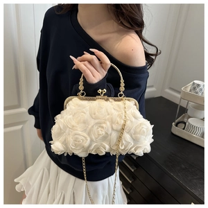 Detail of elegant cream floral evening bag with 3D rose texture and gold ring handle