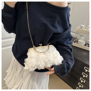 Close-up of white 3D floral evening bag with kiss-lock clasp and gold chain strap