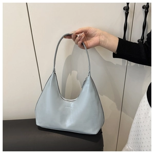 Macro detail of FASHION embossed logo on light blue matte leather handbag with zipper