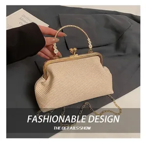 Détail de la pochette tressée crème avec cadre doré et poignée ornée de fleurs