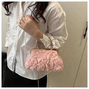 Close-up of pink 3D rose petals and golden floral handle on an elegant evening bag