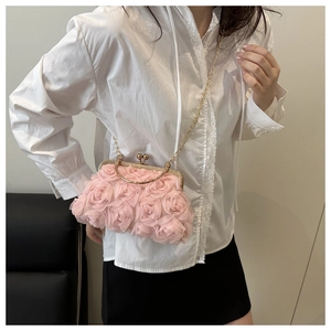 Detail of light pink evening bag featuring 3D tulle flowers and gold chain strap