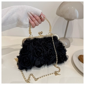 Detail of 3D rose fabric texture on black evening bag with gold metal handle and clasp